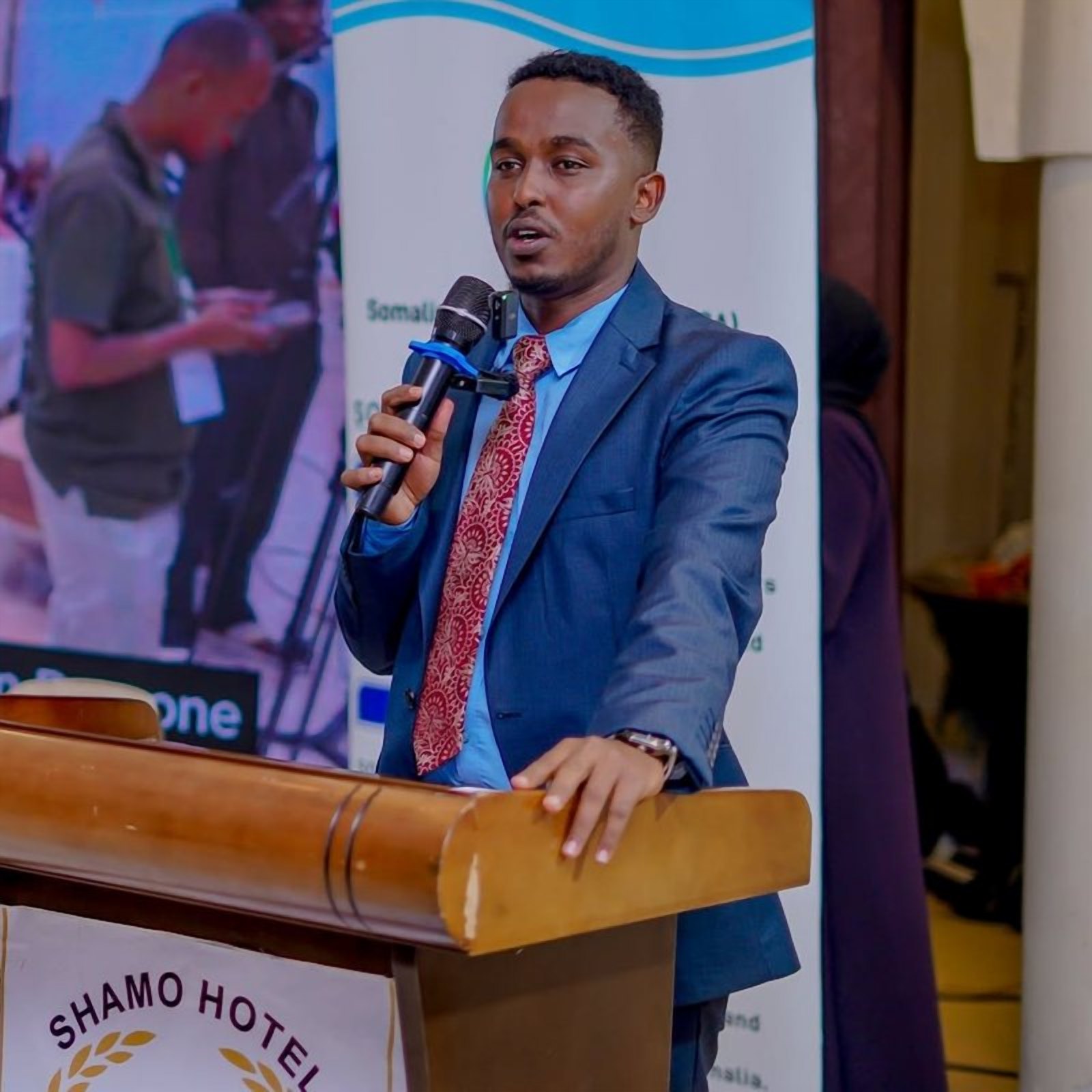 Chairman Zakariye Ismail Sky speaking into a microphone at a conference lectern.